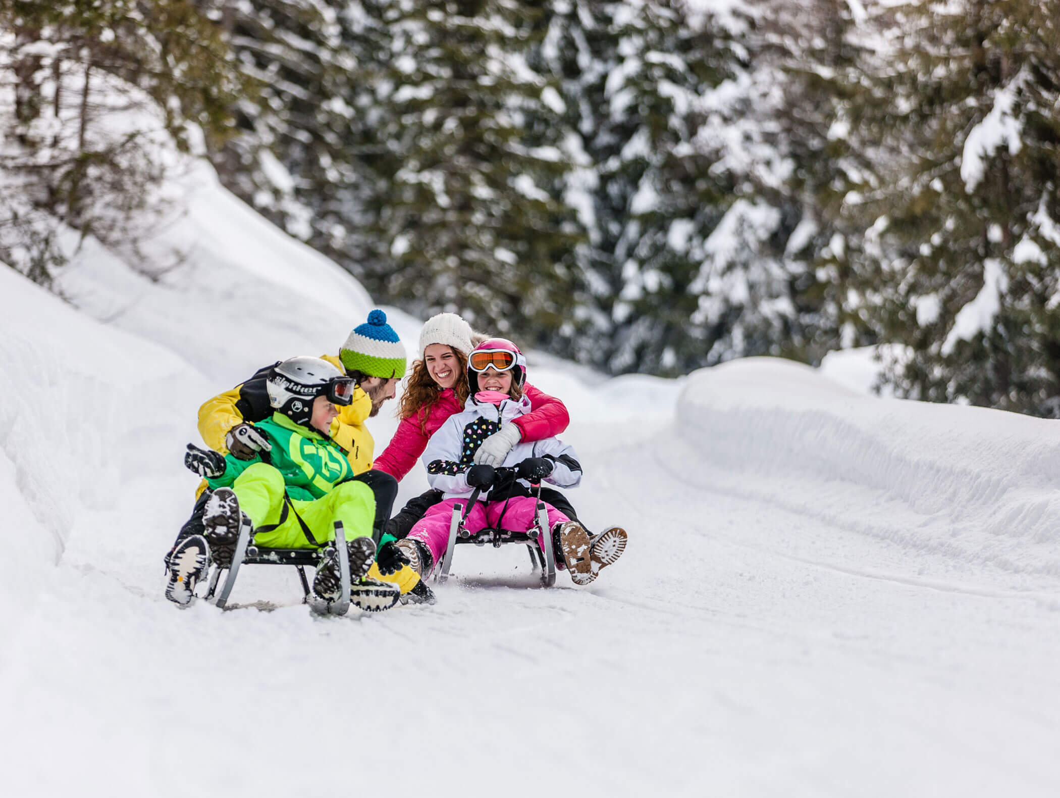 A family of four sledging in Fleres in winter - Knappenhof B&B