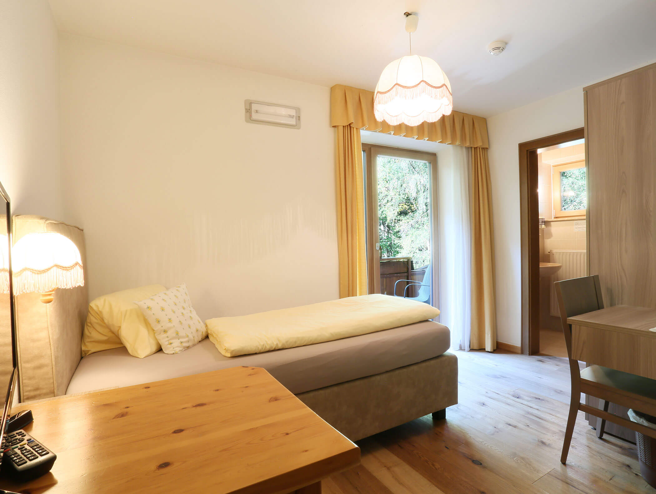 Modern bedroom with wooden floor of the single room Brennero - Knappenhof B&B